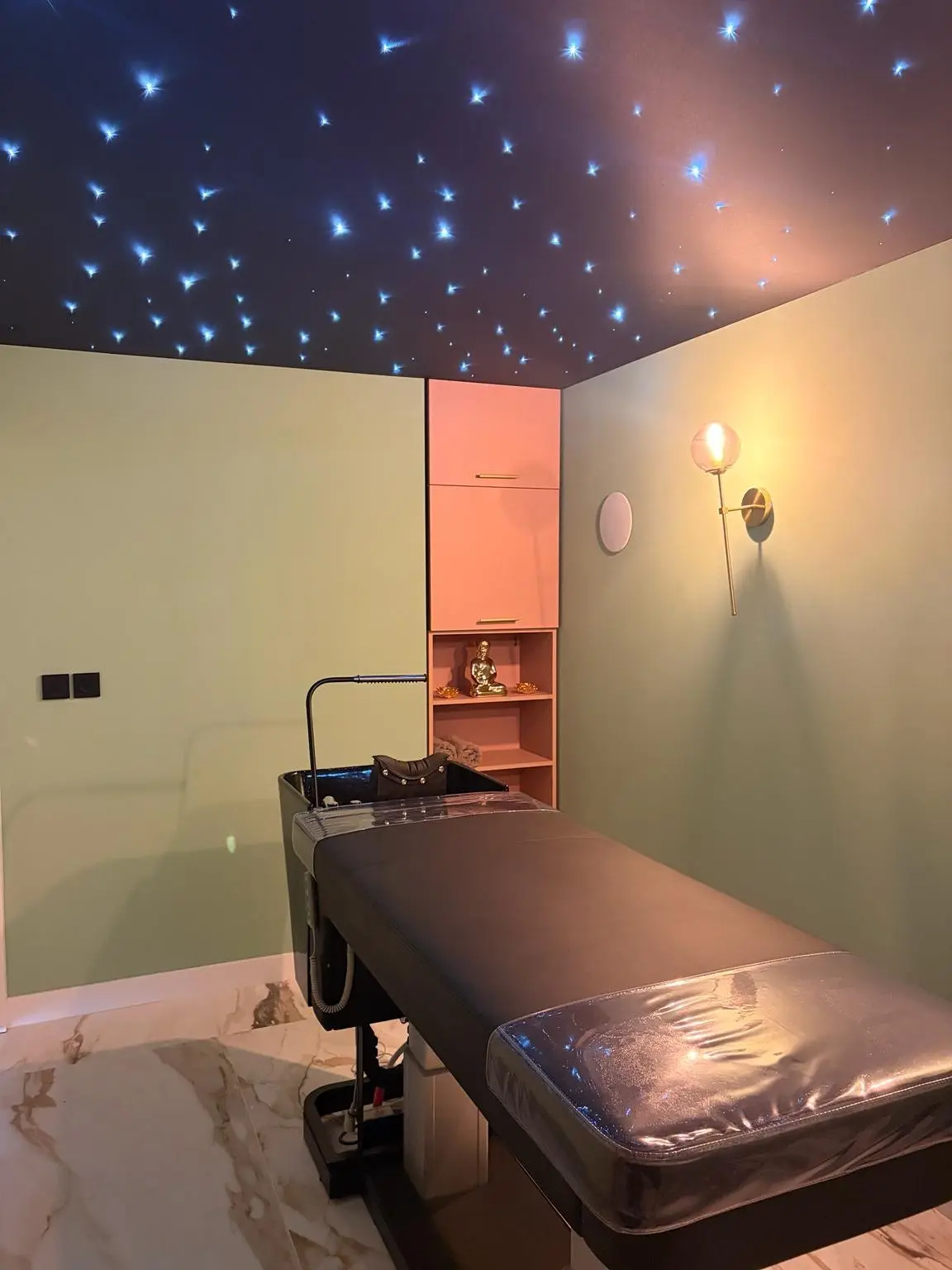 Cabine de massage du salon avec table de soin et plafond étoilé